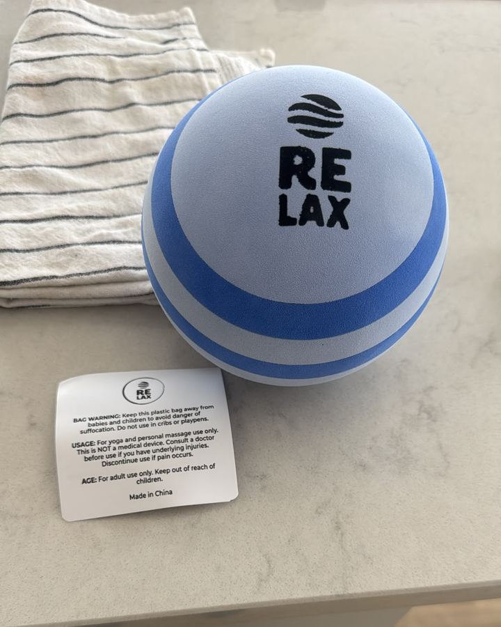 RELAX Massage Ball on a kitchen counter next to its care card